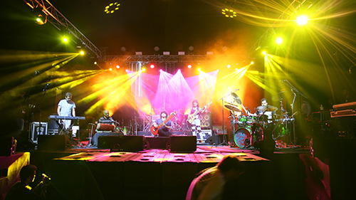 Live band performing on stage with vibrant lighting effects